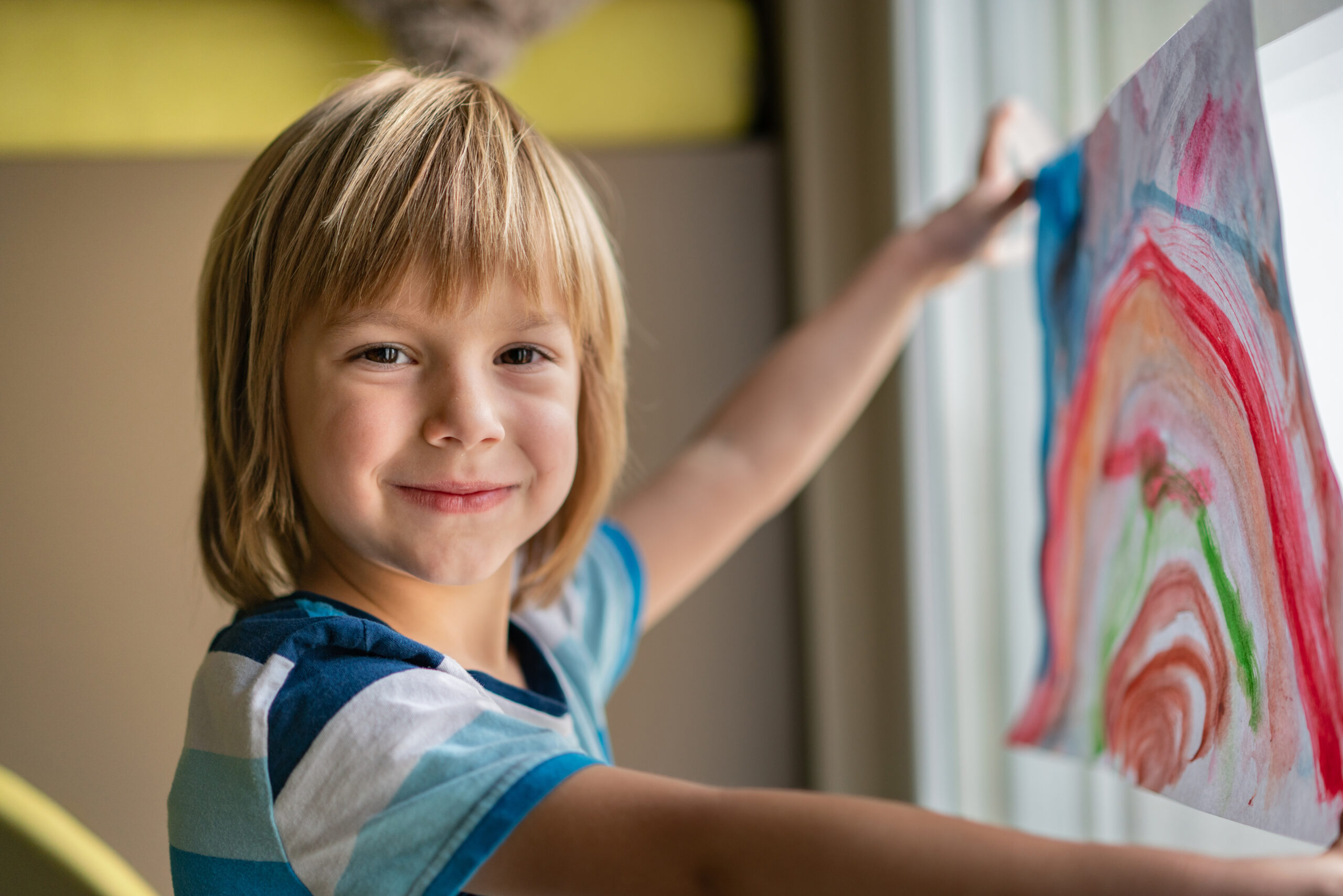 Boy holding his drawing on window during the coronavirus Boy holding his drawing on window during the coronavirus