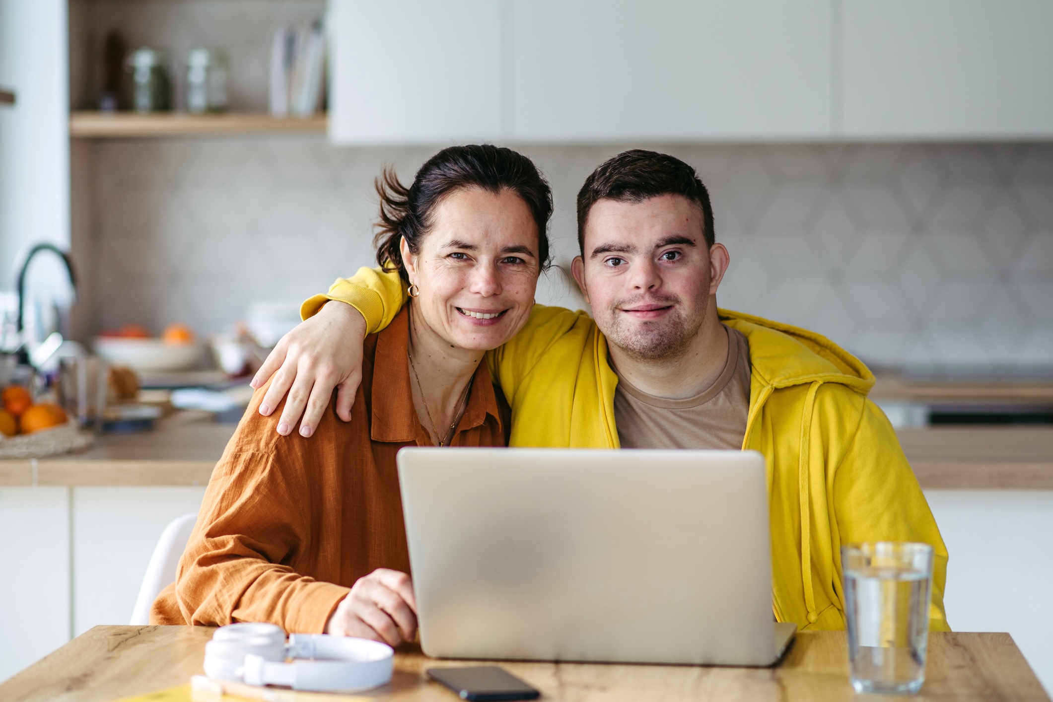 Mom teaching young man with down syndrome, using laptop. Telehealth consultation with doctor. Mom teaching young man with down syndrome, using laptop. Telehealth consultation with doctor.